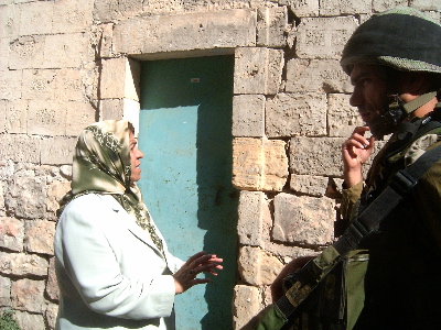 Principal Ferial Abu Haikal tells a soldier that teachers and girls will not go through the cabin at the checkpoint