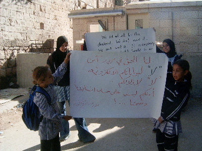 Qurtuba school girls holding their protest placards by the checkpoint